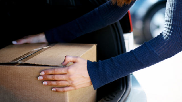 Woman putting box into trunk